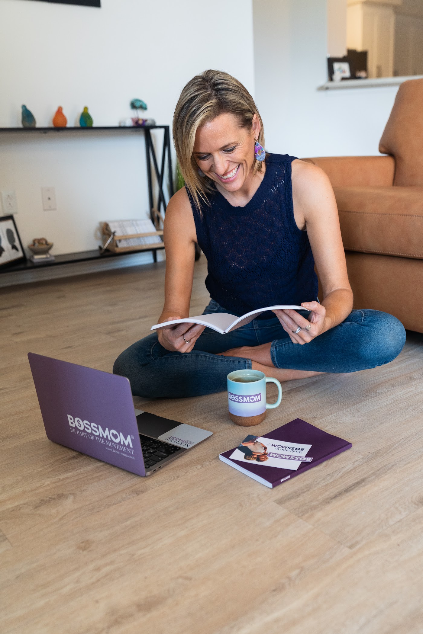 Dana Malstaff reading on the floor with her BossMom laptop and mug