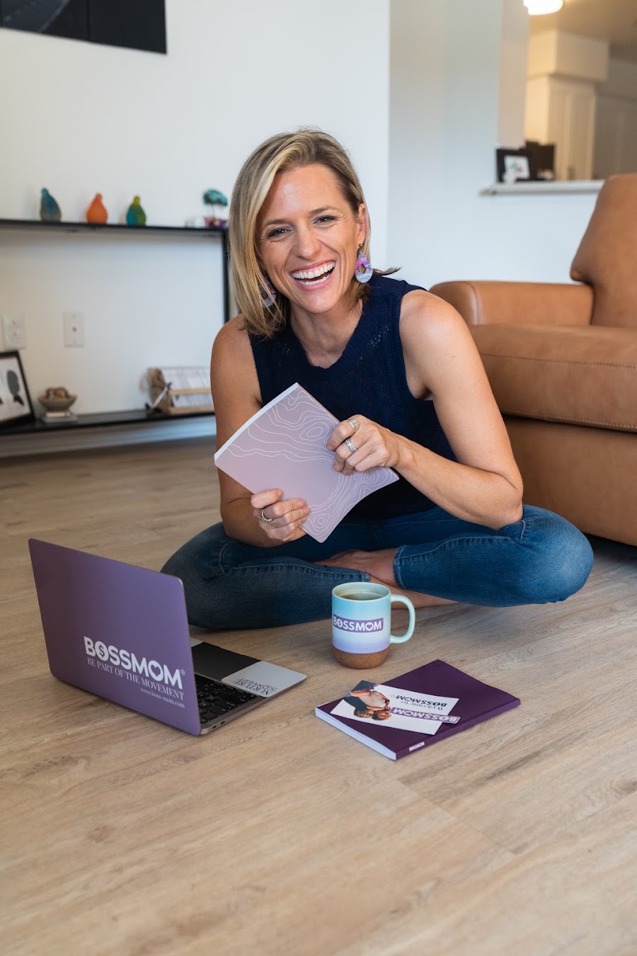 Dana laughing on the floor with her BossMom laptop